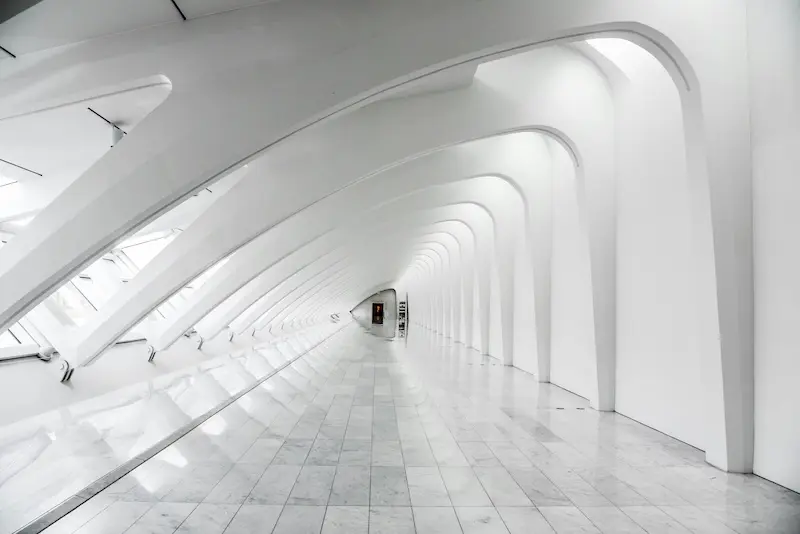 Moderner weisser Gang mit geschwungenen Bögen in minimalistischer Architektur